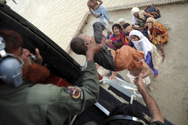 Image: Pakistani army soldiers in a helicopter rescue families stranded by flood water