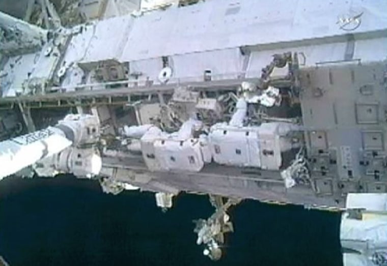 Image: Doug Wheelock and Tracy Caldwell Dyson work head to head to remove a faulty ammonia pump module on the exterior of the International Space Station during their spacewalk