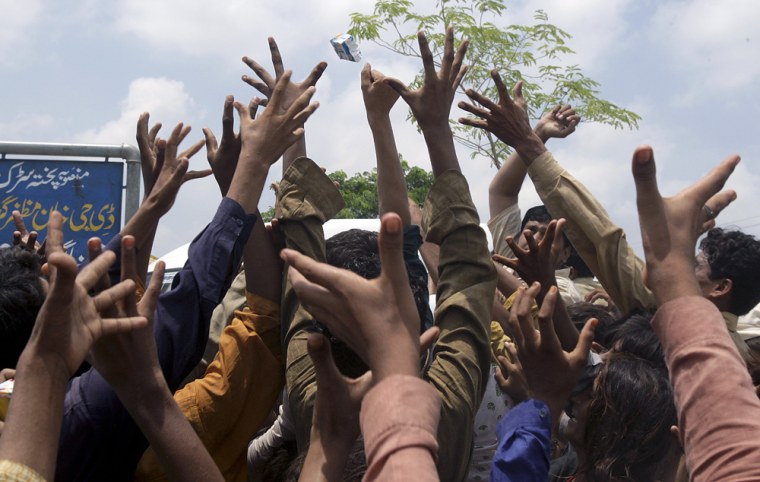 Image: Pakistani villagers jostle for relief food