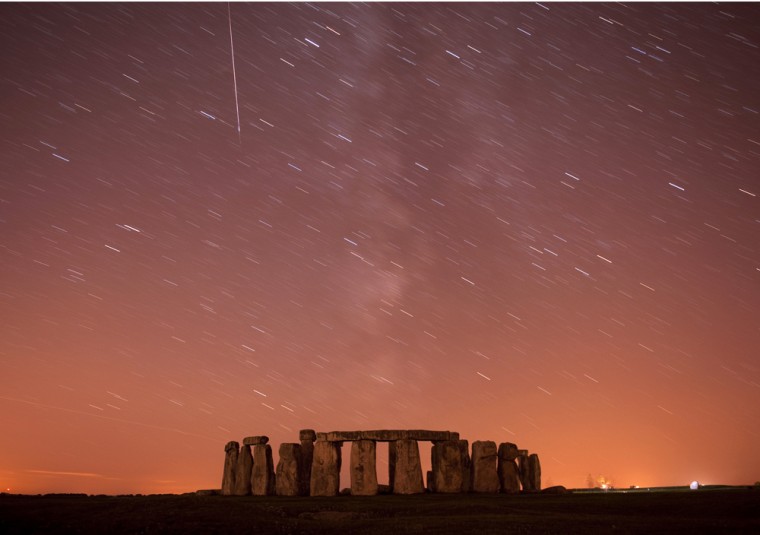 Image: A meteor streaks past stars in the night sky over Stonehenge in Salisbury Plain