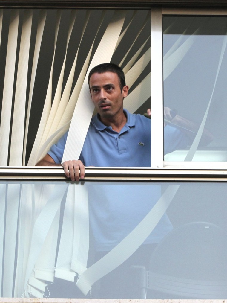 Image: Nadim Injaz looks out of a window at the Turkish embassy in Tel Aviv