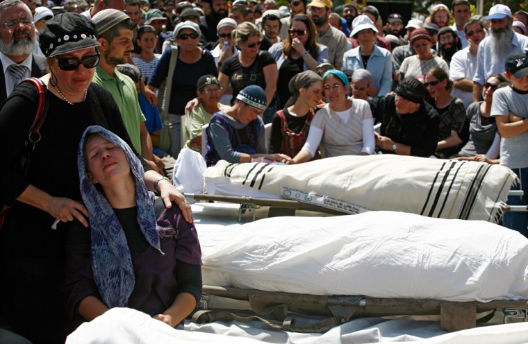Image: Mourners gather around the bodies during funeral in the West Bank Jewish settlement near Hebron