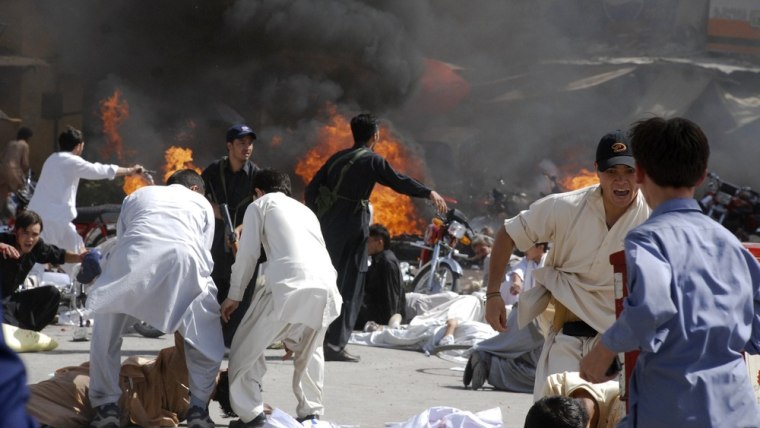 Image: People rush for cover soon after an explosion during a Shiite procession in Quetta, Pakistan on Friday