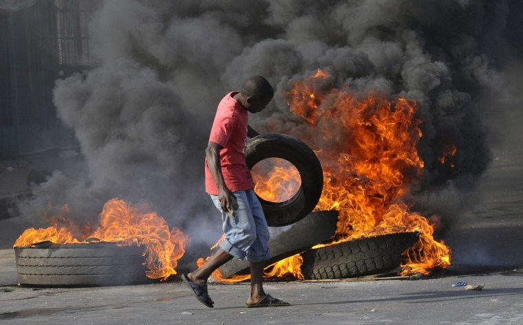 Image: Demonstrator near burning barricade during riots in Mozambique's capital Maputo