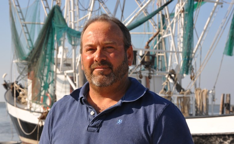Shrimper Tommy Verdin, standing in front of his 100-foot trawler "Cherish" in Grand Isle, La., in May, isn't sure he can make ends meet with prices for Gulf seafood well below their historic average.