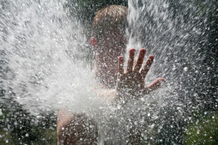Image: A man cools off in a fountain in the southern city of Stavropol