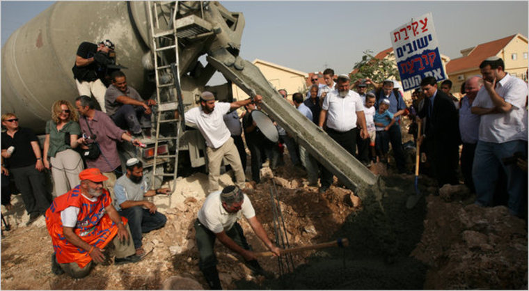 Jewish settlers in the settlement of Kiryat Netafim in the West Bank used a cement mixer to pour a cornerstone for a kindergarten. 