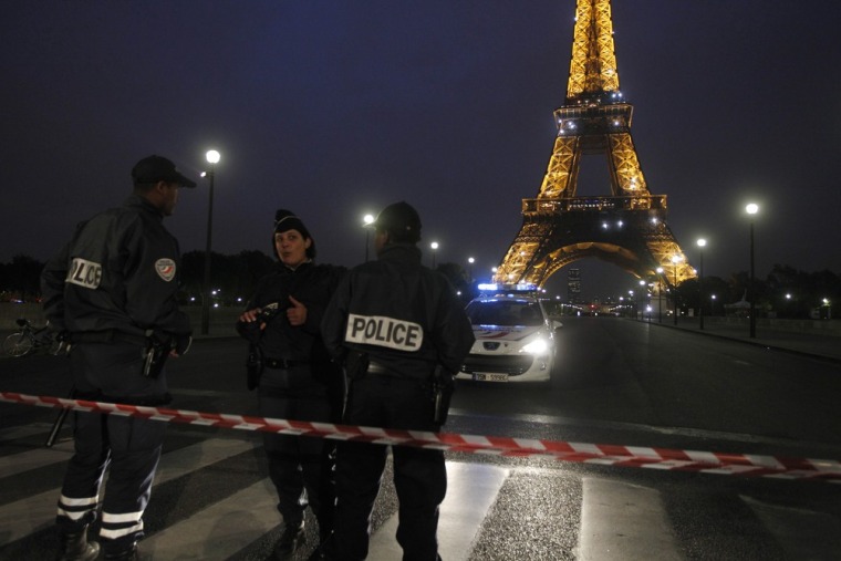 Image: Police stand guard an a bridge across from the Eiffel Tower in Paris after the French tourism landmark and the surrounding park was evacuated following a bomb alert
