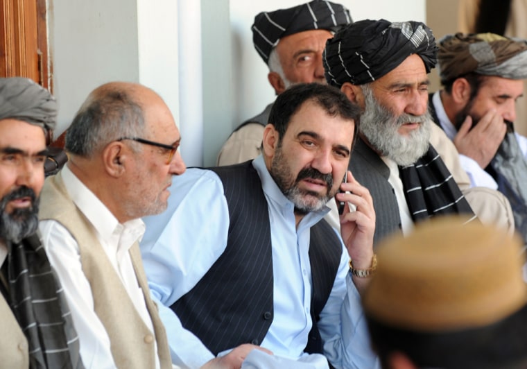Image: Ahmed Wali Karzai (C) talks on the phone
