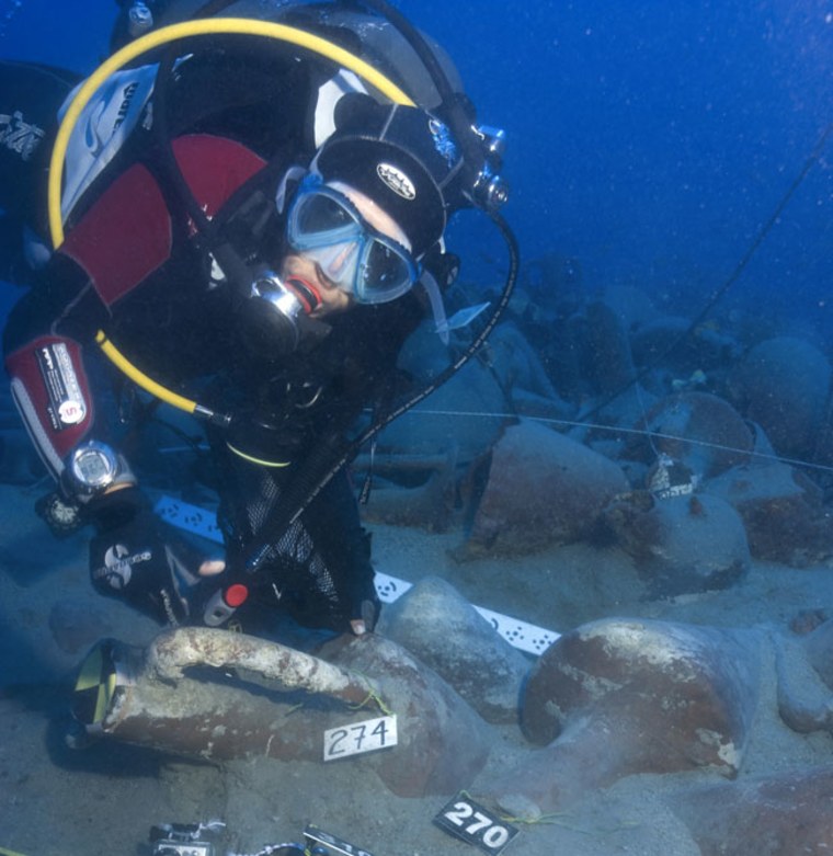Image: Diver swims among shipwreck cargos