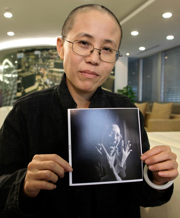 Image: Liu Xia, the wife of Chinese dissident Liu Xiaobo, holds a photo of her husband during an interview in Beijing