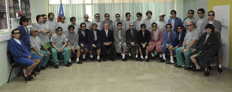 Image: Chilean President Sebastian Pinera poses with the 33 rescued miners inside the Copiapo Hospital