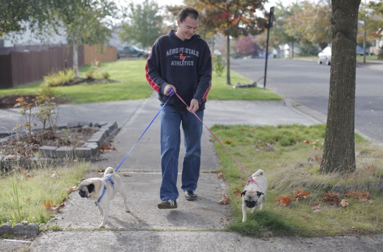 Image: James Davis walks his pugs Gus and Leah near his home in Puyallup, Wash. before heading to math class at Clover Park Technical College
