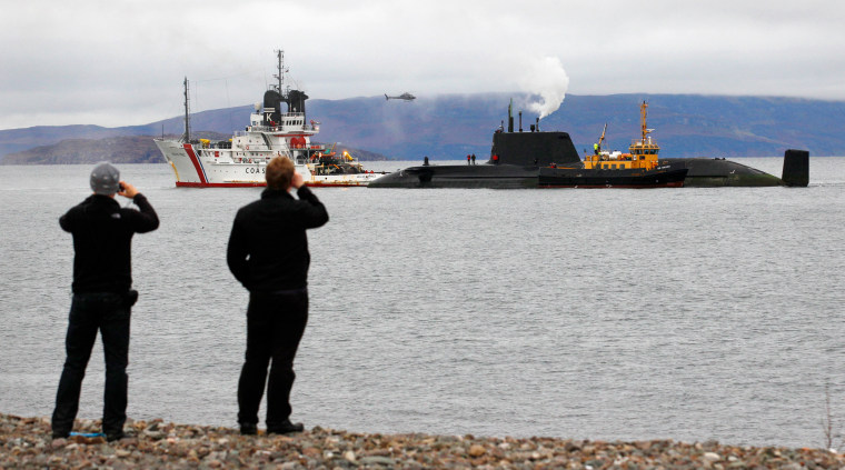 Image: People on a beach watch as crew work on the Royal Navy nuclear-powered submarine HMS Astute after it ran aground off the Isle of Skye
