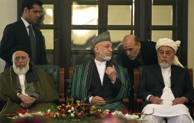 Image: Afghan President Hamid Karzai speaks to his staff during the inauguration ceremony for the High Peace Council at the presidential palace in Kabul