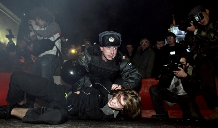 Image: Riot police officers detain protesters in central Moscow