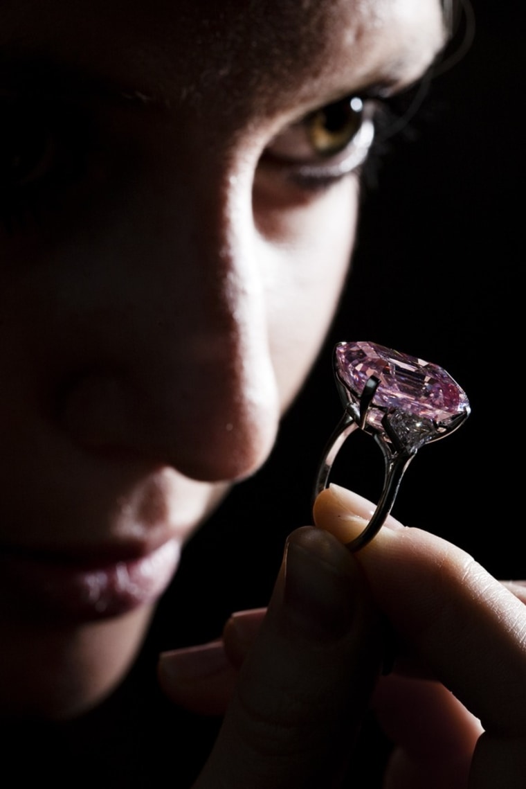Image: An employee poses with a 24.78 carat Fancy Intense Pink diamond at Sotheby's in Geneva