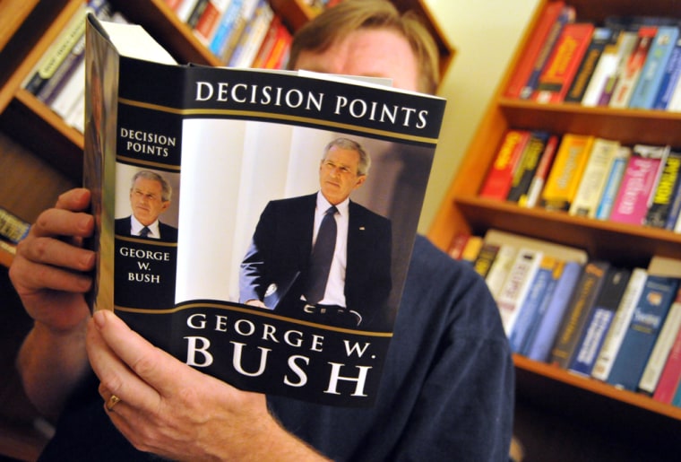 Image: A man reads the new memoir by former US President George W. Bush