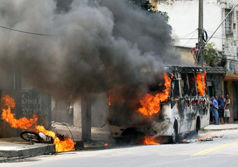 Image: Local residents stare at a burning bus a