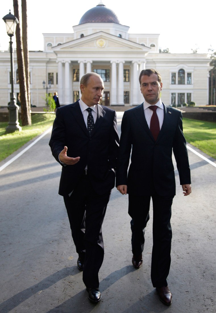 Image: Russia's President Medvedev (R) and Prime Minister Putin walk during their meeting at the Gorki presidential residence outside Moscow