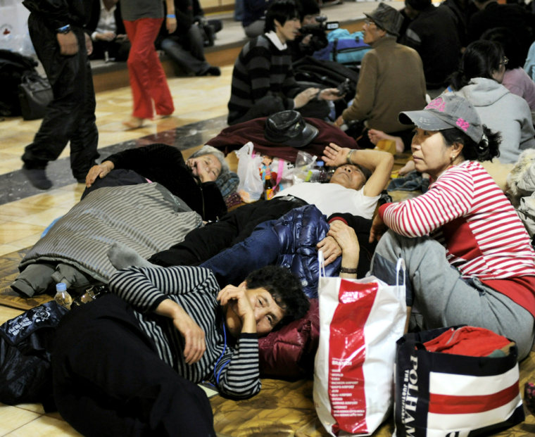 Image: People evacuated from nearby Yeonpyeong island sit on the floor of a spa being used as temporary shelter in Incheon