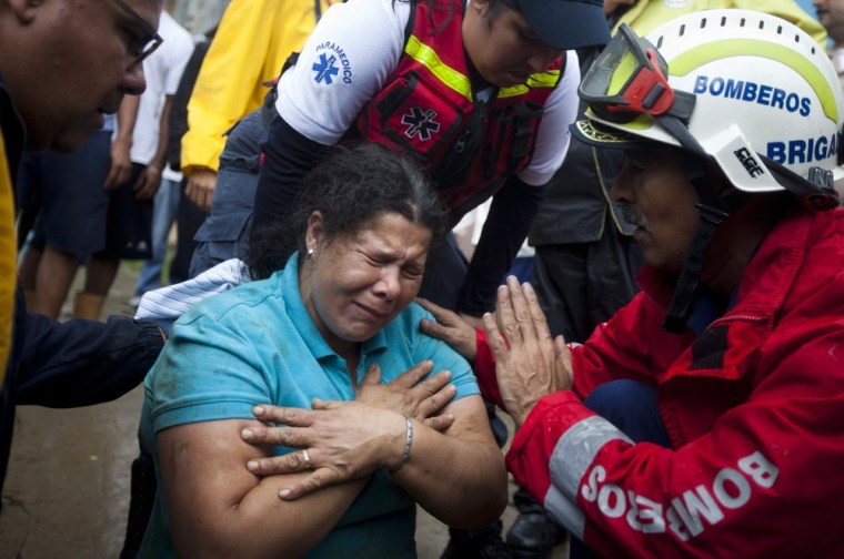 Image: A woman cries after being rescued from her house, which had collapsed during torrential rains, in Tamanaquito