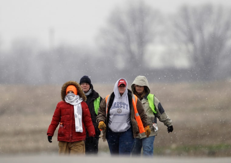 Image: Volunteers Lisa Borton, from left, Diane Molitierno, Joyce Beatty, and Mona Leininger search a field in Williams County outside Pioneer,