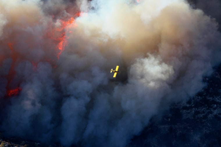 Image: A firefighting aircraft flies over a forest fire on Mount Carmel near Haifa
