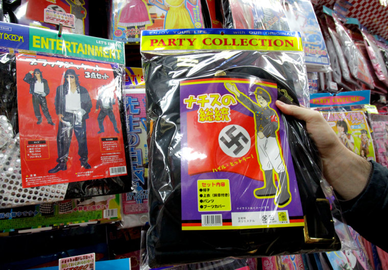 Image: A Nazi costume, which includes a black jacket with a swastika armband and a sketch resembling Adolf Hitler on the package, with the phrase \"Heil Hitler\"