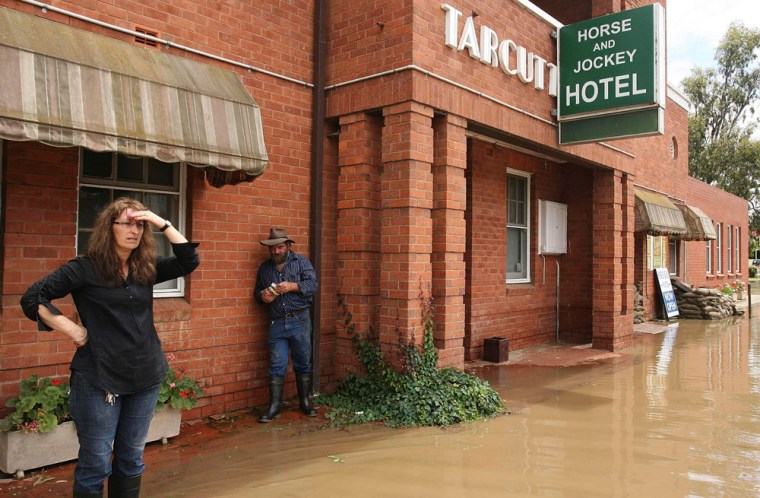 Image: Publicans Ian Anderson and his wife Alma watch the rising flood waters at the Horse and Jockey Hotel