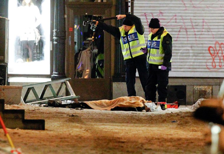 Police forensics experts examine the remains of a suspected suicide bomber. (©Fredrik Persson/EPA)