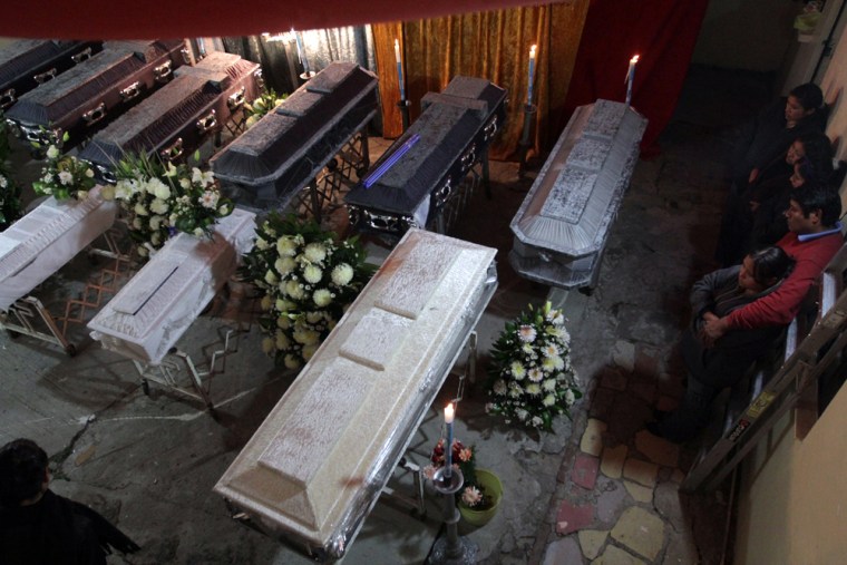 Image: Members of the Medel Brito family look at the 10 coffins of their dead relatives who were killed in a Pemex oil pipeline explosion in San Martin Texmelucan