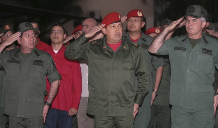 Image: Venezuela's President Chavez, General-in-Chief Rangel Silva, and Defence Minister Mata Figueroa salute during a ceremony at a barrack in Maracay