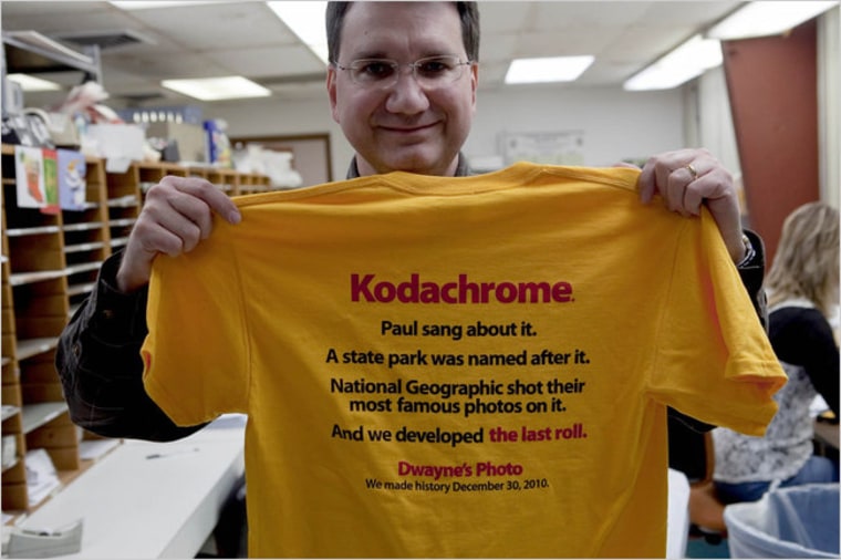 An employee holds a T-shirt commemorating the final roll of Kodachrome film to be developed at Dwayne's Photo in Parsons, Kan., on Dec. 28, 2010. The lab is the last one processing the 75-year-old film and will process the final roll on Dec. 30. (Steve Hebert/The New York Times)