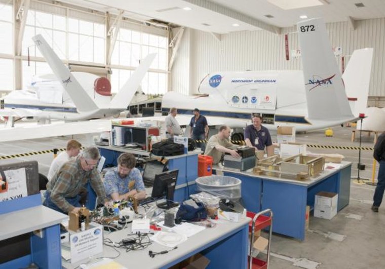 Atmospheric scientists check out their instruments in a hangar at NASA Dryden Flight Research Center at Edwards Air Force Base, Calif., before installation aboard one of NASA's two Global Hawk aircraft for the Global Hawk Pacific environmental science mission. 