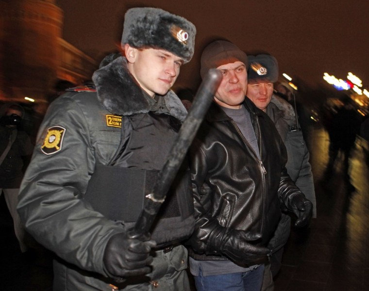 Image: Russian police officers detain a man suspected of planning a racist rally outside the Kremlin