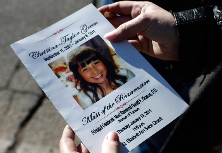 Image: Woman holds funeral service program for Christina Green in Tucson