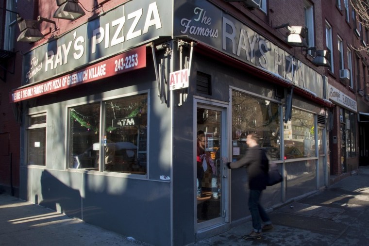 Image: Pedestrians stroll past Famous Ray's Pizza at West 11th St. and 6th Avenue in New York.