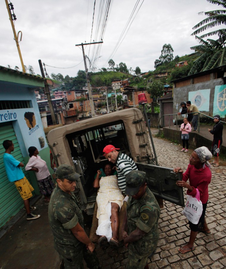 Image: Brazilian soldiers tend to a landslide victim in Nova Friburgo