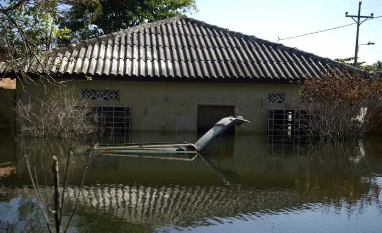 Image: A car remains under the water in front o