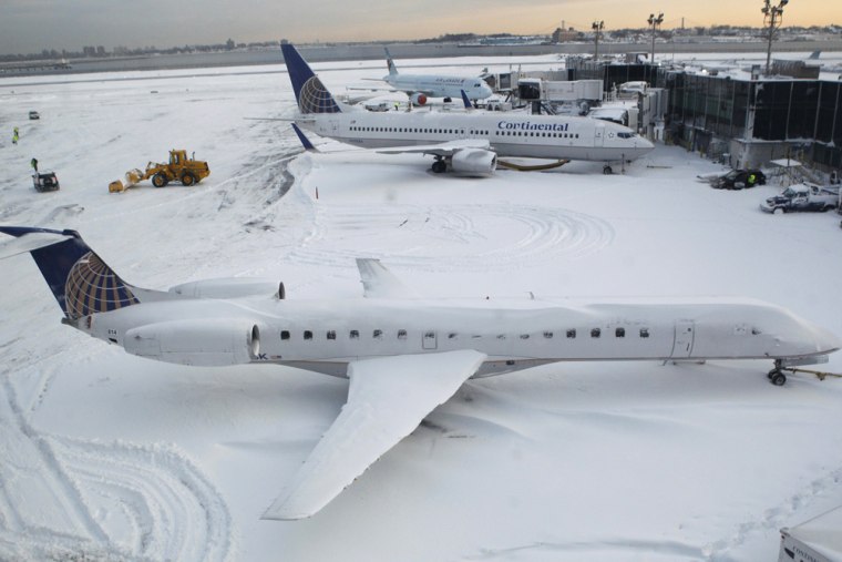 Image: Planes are grounded on a snow covered tarmac at New York's LaGuardia Airport