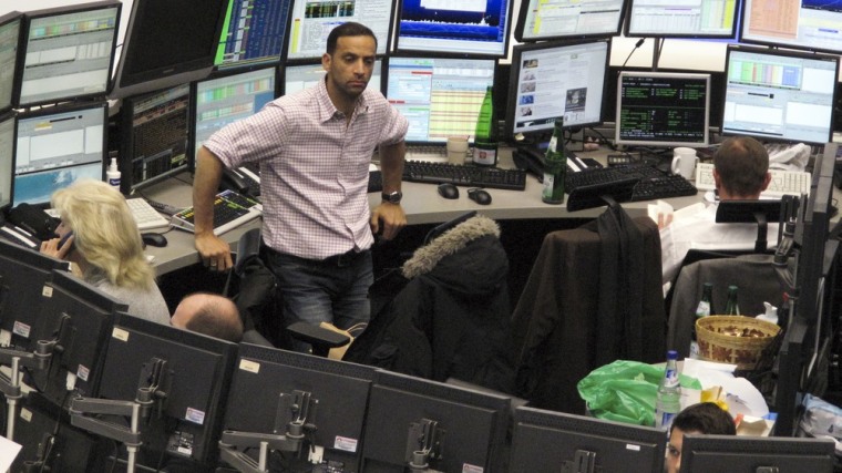 Image: Traders are pictured at their desks at the Frankfurt stock exchange