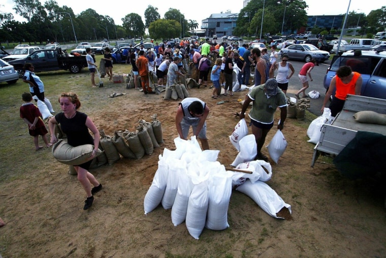 Image: Residents fill and collect sand bags fro