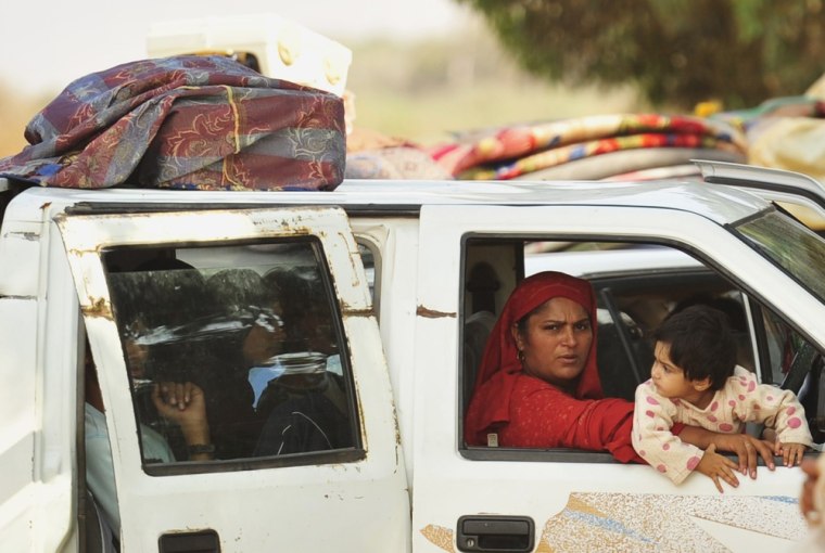 Image: A family fleeing from the fighting between pro-Gaddafi and anti-Gaddafi forces drive pass Khamseen Gate