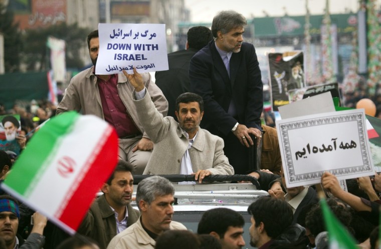 Image: Iranian President Ahmadinejad holds a placard as he takes part in a rally to mark the 32nd anniversary of the Islamic Revolution in Tehran