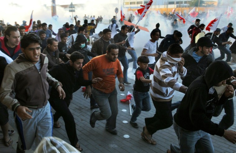 Image: Bahraini protesters run for cover from t