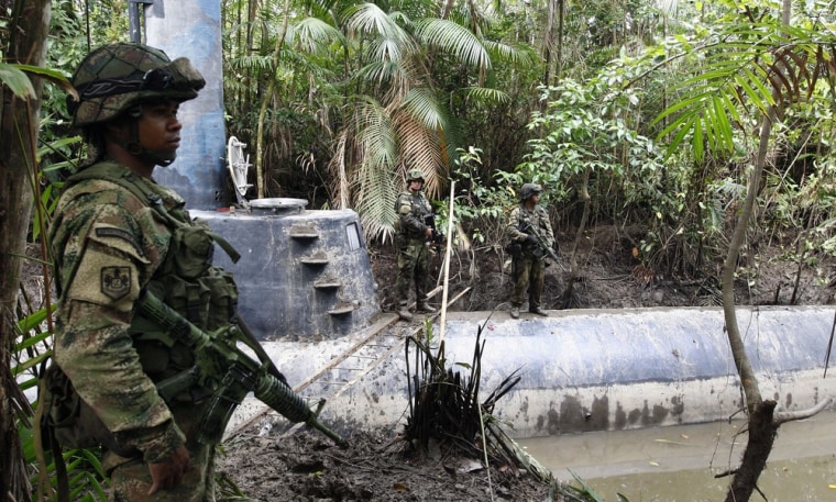 Image: Members of the Colombian Navy stand guard near a seized submarine built by drug smugglers