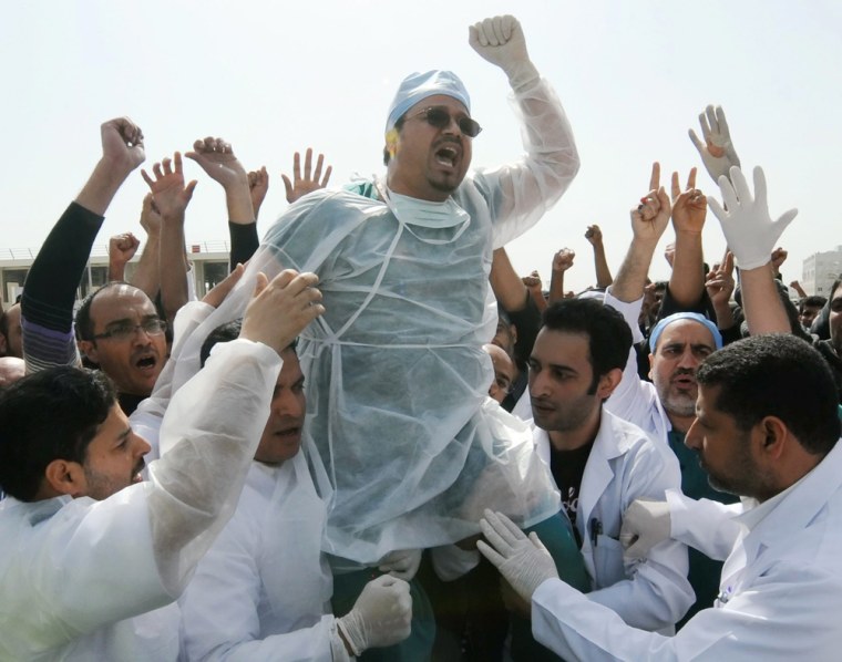 Image: Medical workers react to news that paramedic crews at protest were attacked by pollice in Bahrain