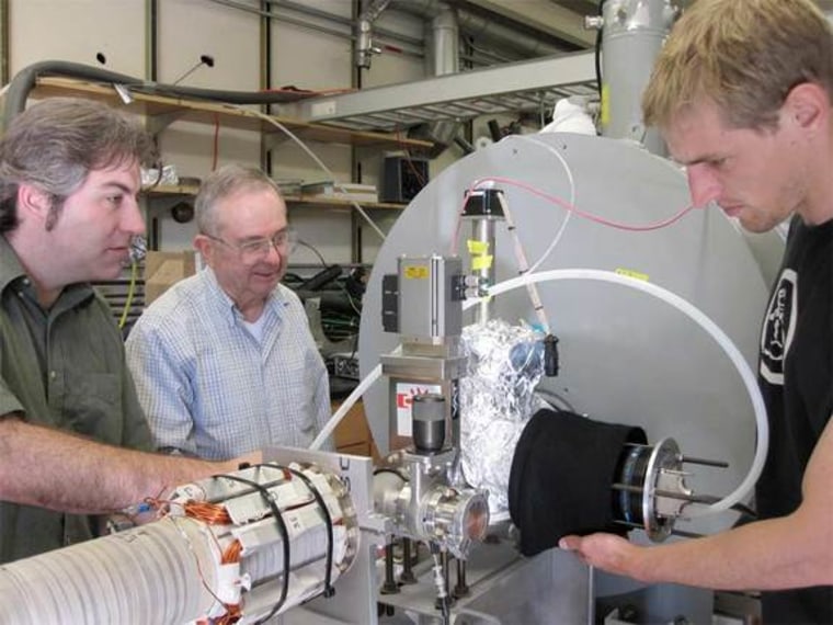 University of California, San Diego,  physicists James Danielson, Clifford Surko and Craig Schallhorn, left to right, inspect the apparatus they are using to develop the world's largest trap for low-energy positrons, planned to hold a trillion or more antiparticles.