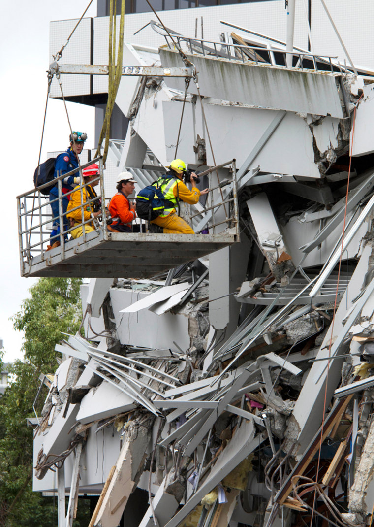 Image: A rescue worker uses a thermal imaging camera to search for signs of life in the PGG building in central Christchurch